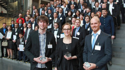 Gruppenfoto der drei Preisträger des Ferchaupreises, im Hintergrund die restlichen Absolventen (Bild: Manfred Stern / TH Köln)
