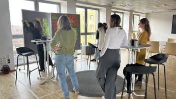 Mehrere Personen an Stehtischen