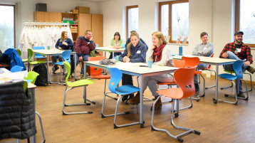 Mehrere Personen an Tischen Mehrere Personen an Tischen