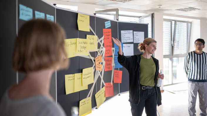 Personen vor einer Pinnwand Personen vor einer Pinnwand