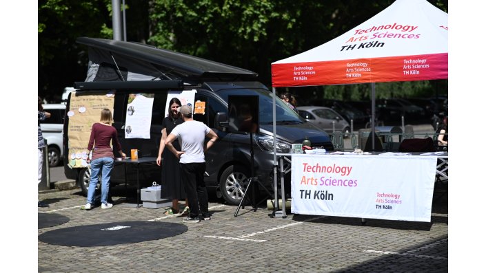 Pavillon, Bus und Personen im Gespräch