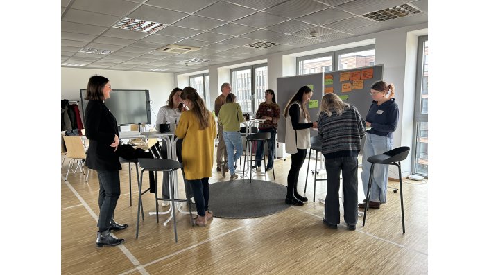 Mehrere Personen an Stehtischen