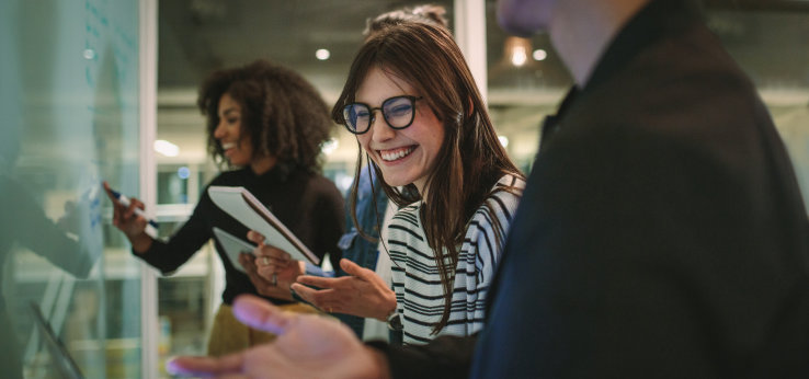 Junge Menschen stehen vor einer Tafel, eine Person lacht in die Kamera (Bild: AdobeStock)