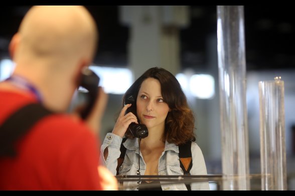 Personen mit Telefonhörer am Messestand