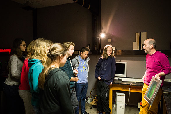 Anton Kraus zeigt einer Gruppe Jugendlicher ein Hologramm.