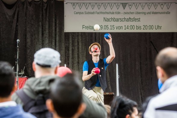 Ein Clown jongliert auf einer Bühne