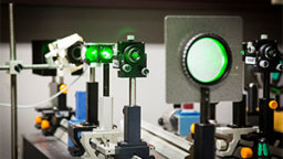 Grüner Laser leuchtet durch verschiedene Linsen (Bild: Heike Fischer/FH Köln)