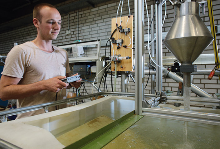 Ein Mann steht vor einem Wasserbecken. Er hält eine Fernsteuerung in der Hand. Ein Mann steht vor einem Wasserbecken. Er hält eine Fernsteuerung in der Hand.