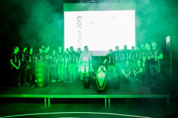 Das Team eMotorsports Cologne versammelt sich auf der Bühne - im Mittelpunkt der "eMC15"