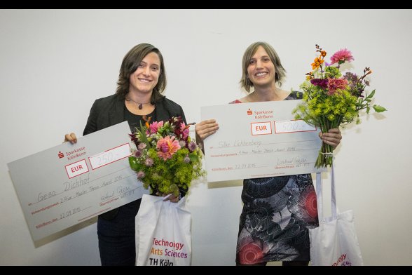 Zwei Frauen halten übergroße Schecks hoch.