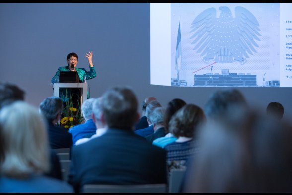 Prof. Dr. Rita Süssmuth erinnert an den Bundestagsadler (1953) von Ludwig Gies. Da die Figur der Gipsplastik aufgeplustert erschein, erhielt der Adler den Spitznamen "Fette Henne"
