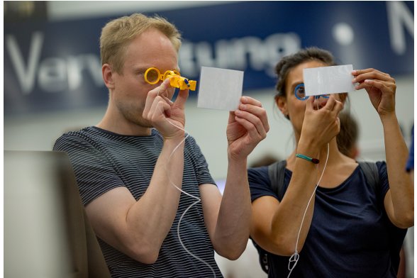 Zwei Personen gucken durch eine Brille auf eine Karte.