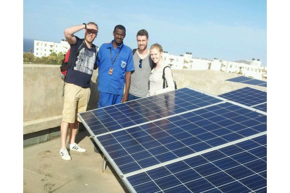 Vier Personen stehen hinter einer Photovoltaikanlage 