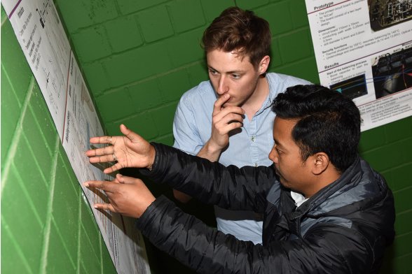 Patrick Littau und ein Besucher dikutieren das Poster