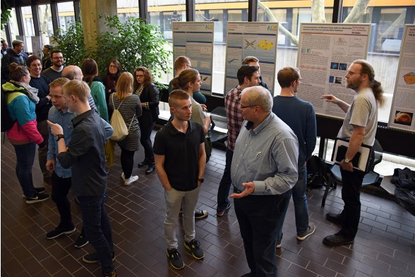 Professoren und Studierende diskutieren in kleineren Gruppen
