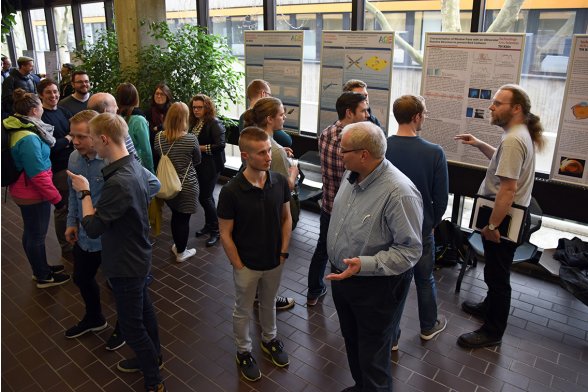 Professoren und Studierende diskutieren in kleineren Gruppen