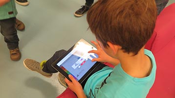 Sitzender Junge mit einem Tabletcomputer (Bild: Haike Meinhardt/TH Köln)