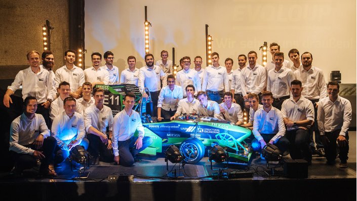 Gruppenfoto des Teams eMotorsport Cologne mit dem neuen Rennwagen.