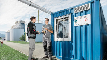 Zwei Menschen vor einem Container (Bild: Markus Ellersdorfer)