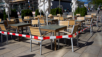 Leere Tische und Stühle einer Außengastronomie (Bild: Let pictures tell the Story/iStock.com)
