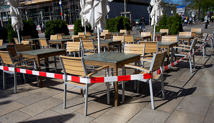 Leere Tische und Stühle einer Außengastronomie
