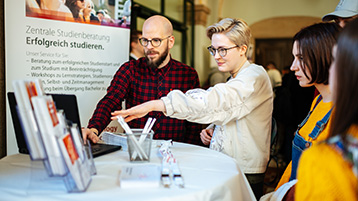 Bastian Reinhard, Teamleiter der Zentralen Studienberatung, im Gespräch mit Studierenden.  (Bild: Costa Belibasakis/TH Köln)