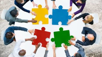 Schmuckbild mit Menschen an einem runden Tisch, die Puzzleteile halten (Bild: Adobe Stock) Schmuckbild mit Menschen an einem runden Tisch, die Puzzleteile halten (Bild: Adobe Stock)