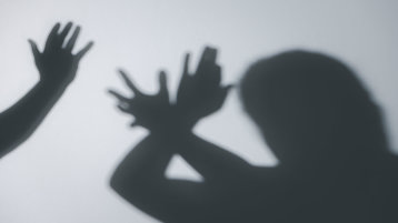 Darstellung von Gewalt: Einr Hand ist bedrohlich über dem Kopf einer anderen Person erhoben, die den Schlag mit ihren Armen versucht abzuweheren.  (Bild: doidam10/AdobeStock)