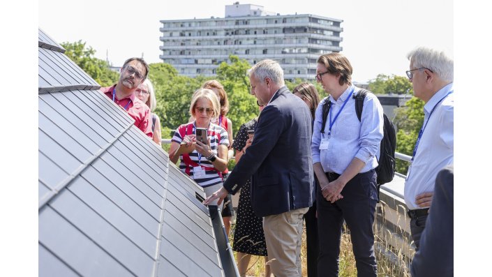 Delegationsmitglieder auf dem Dach des Campus Deutz vor der Photovoltaikanlage