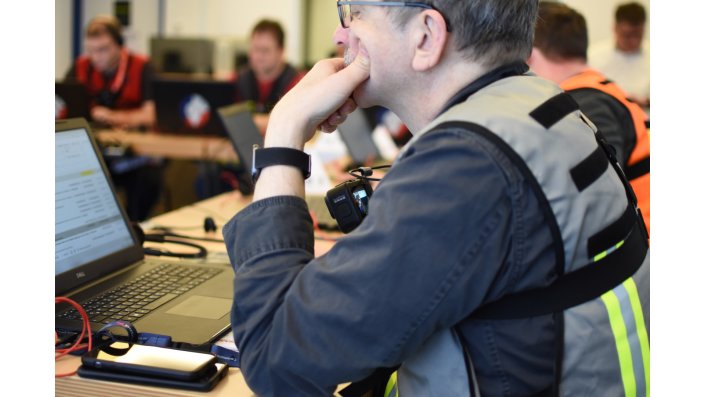 Ein Mitglied des Experimentalstabs schaut auf das Display seines Laptops. 