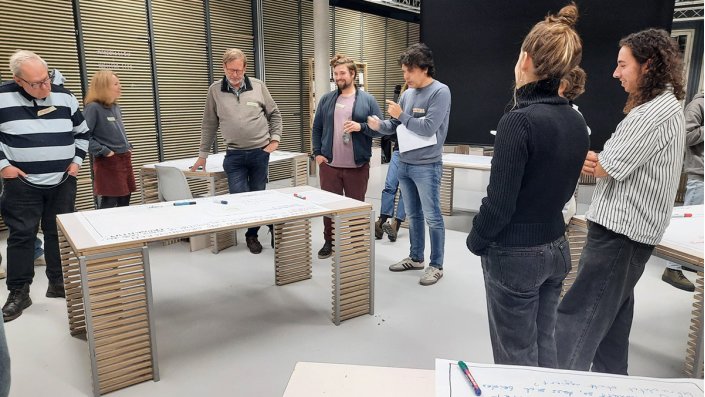 ein Mann neben der Projektion einer Präsentation vor einem Publikum