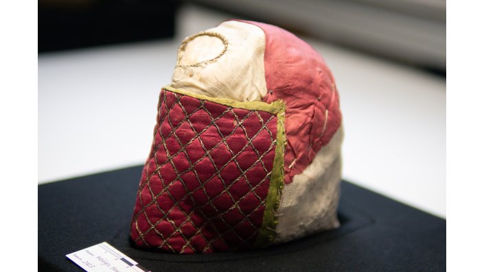 Ein Reliquienschädel mit roter Stoffumhüllung,