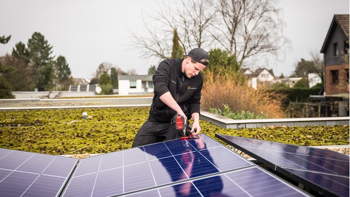 Im KlimaVeedel Neubrück werden Solarmodule auf einem Dach montiert. 