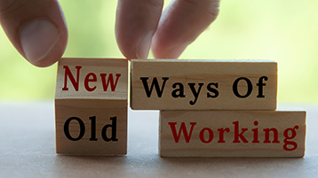Auf drei Holzklötzchen steht "Old Ways of Working". Eine Hand bewegt das erste Klötzchen, sodass "New Ways of Working" zu lesen ist.  (Bild: Jerome Maurice/Adobe Stock)