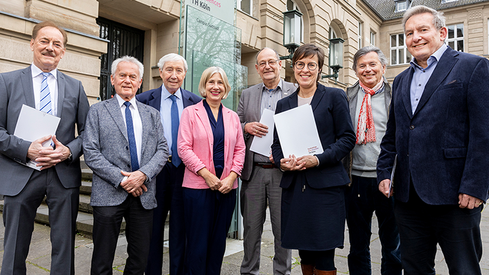 Die acht Verantwortlichen der TH Köln und der beteiligten Stiftungen bei der Vertragsunterzeichnung stehen vor dem Hauptgebäude der TH Köln an der Claudiusstraße