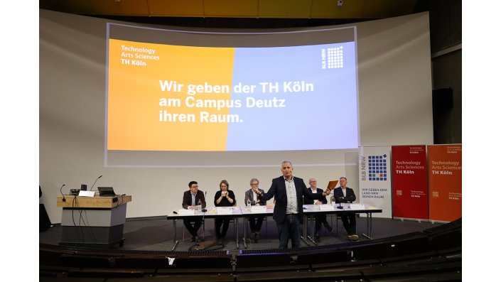 Sechs Personen auf dem Podium, davor der Moderator