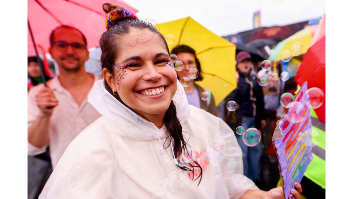 Eine buntkostümierte, feiernde Person auf dem CSD