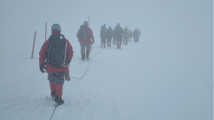 mehrere Personen auf Expedition im Schneesturm