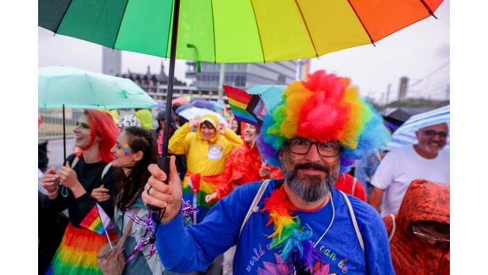 Eine buntkostümierte, feiernde Person auf dem CSD