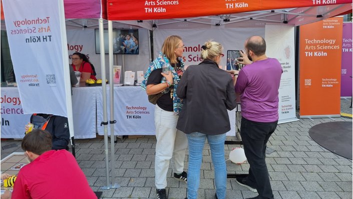 drei personen vor einem Veranstaltungszelt
