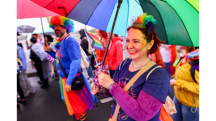 Eine buntkostümierte, feiernde Person auf dem CSD