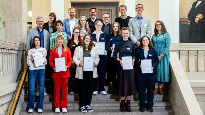[Gruppenfoto] Mehrere Männer und Frauen lächeln in die Kamera.