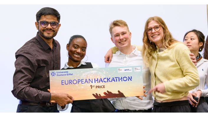 [Foto] Fünf Menschen halten gemeinsam ein großes Schild mit der Aufschrift "European Hackathon 1st Price" und den Logos von Université Gustave Eiffel sowie 4Fit France. 