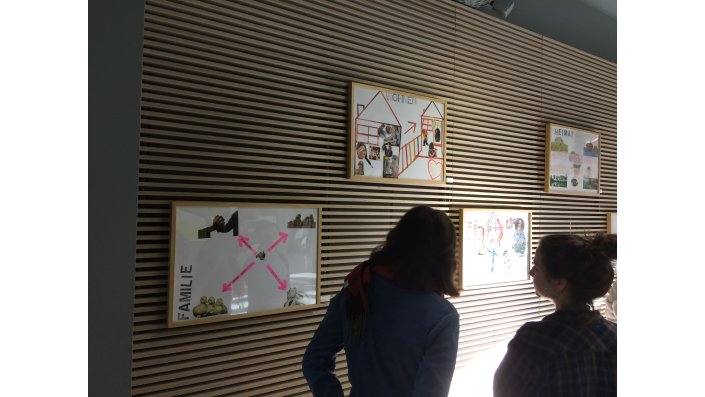 Zwei Studentinnen betrachten Bilder der Ausstellung "Durch meine Augen"