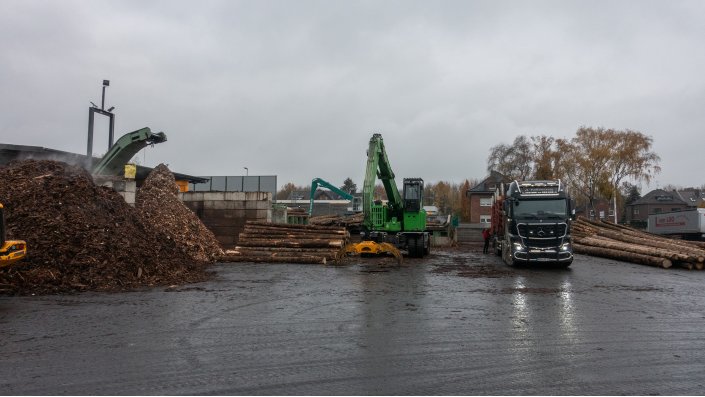 Ein Blick auf einen der Werkshöfe zeigt mehrere Arbeitsschritte. Unter anderem sind links im Bild zwei Haufen zu sehen. Es handelt sich um die Rinde, sortiert nach Fichten- und Douglasienrinde, die z.B. zu Mulch weiter verarbeitet werden.