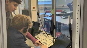 Schüler in einer Dolmetschkabine am ITMK