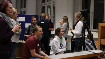 Viele Menschen sitzen vor einem Bildschirm