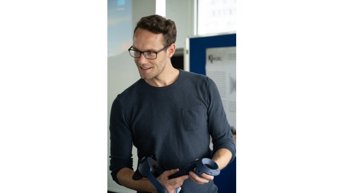 Ein Mann mit einer VR-Brille in der Hand