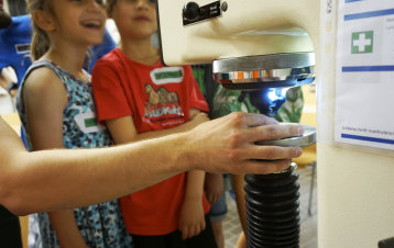 Kinder stehen gespannt vor dem Härteprüfgerät