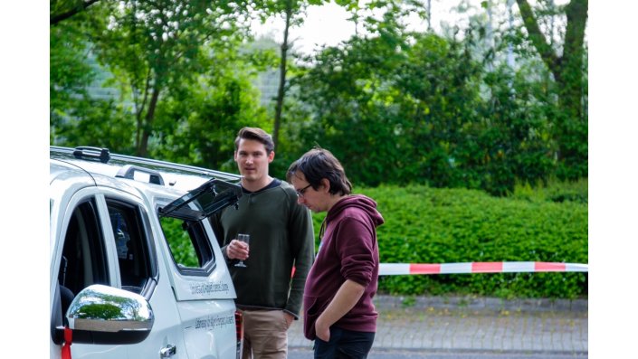 Besucher betrachten die im Fahrzeug verbaute Technik.